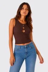 Top sin mangas al cuerpo, de color blanco, confeccionado en tejido acanalado, con diseño cut-out frontal en el escote.