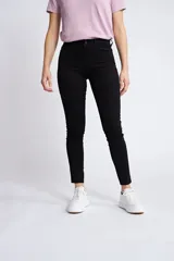 Pantalón de gabardina negro con corte skinny, estilo chupín, con cinco bolsillos y cierre frontal con cremallera y botón.