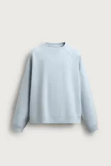 Buzo celeste de corte regular fit confeccionado en tejido con mezcla de algodón y estructura de piqué. Cuenta con cuello redondo, manga larga y acabados en rib.