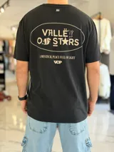 Remera negra de corte oversize con moldería amplia y mangas cortas. Presenta un gran estampado en la espalda dentro de un óvalo con tipografía estilo gótico y la inscripción "Valley of Stars", junto con texto descriptivo y logo de la marca.
