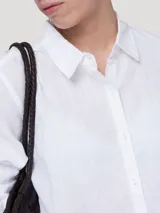 Blusa de lino orgánico color blanco, con cuello camisero, cierre frontal con botones y mangas largas.