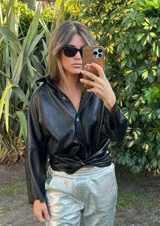 Camisa de cuero color fucsia, de corte recto, con cuello clásico y cierre frontal con botones.