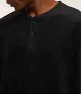 Camisa de pijama de manga larga confeccionada en tejido plush color negro, con cuello redondo y cierre frontal parcial con botones.