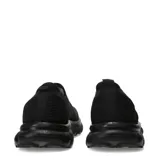 Championes urbanos tipo slip-on de color negro, confeccionados en tejido de punto elástico con suela de goma robusta y diseño ergonómico.