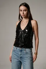 Top negro de poliéster con lentejuelas, escote halter profundo y diseño al cuerpo sin mangas.