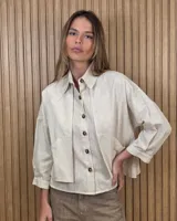 Sobrecamisa de lino color beige, con cuello camisero, cierre frontal de botones carey, mangas largas y bolsillos frontales con solapa.