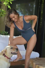 Malla enteriza de diseño cruzado en color azul con detalles de ribetes en tono lila metalizado. Presenta un escote en V profundo y una textura acanalada en toda la prenda.