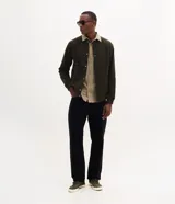 Campera bomber masculina de terciopelo cotelé color beige, con cuello redondo, mangas largas, cierre frontal de botones forrados, bolsillos laterales y terminaciones de elástico en puños y cintura.