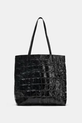 Bolso shopper de cuero con estampado animal tipo cocodrilo, color negro y acabado brillante. Cuenta con doble asa de hombro y un bolsillo interior.