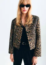 Chaqueta corta de corte recto con estampado de leopardo, cuello camisero, manga larga, bolsillos delanteros de parche y cierre frontal con botones.