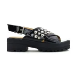 Sandalias con plataforma baja, color beige, con capellada de material símil charol y tachas decorativas.