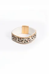 Brazalete rígido con estampado animal print de leopardo, borde superior e inferior con cadena dorada y línea de strass. Cierre magnético dorado.