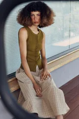 Falda midi de tiro alto con estampado de cuadros, diseño cruzado y detalle de botón en la cintura.
