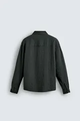 Camisa de corte relajado confeccionada en tejido fluido con mezcla de viscosa. Presenta cuello solapa, cierre frontal con botones y manga larga con puños abotonados.