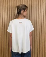 Remera básica de algodón color blanco crudo, con escote en V y corte evasé de manga corta.