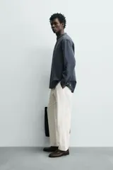 Pantalón de corte relajado confeccionado en una mezcla de algodón y lino. Presenta cintura elástica con cordón ajustable, bolsillos laterales y bolsillos traseros de vivo.