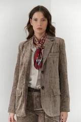 Blazer color visón de terciopelo con forro animal print, hombreras, botones frontales y en mangas.