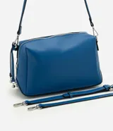 Bolso tipo shoulder de diseño rectangular estructurado en color azul. Cuenta con cierre metálico superior, herrajes plateados y correa larga ajustable y removible.