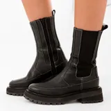 Bota corta tipo chelsea de cuero vacuno color negro, con suela de goma track, cierre lateral interno y elástico lateral externo.