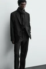 Blazer de corte regular confeccionado en tejido de lana italiana. Presenta cuello con solapas de muesca, cierre frontal de un botón, bolsillos laterales con solapa y bolsillo de vivo en el pecho. Incluye aberturas en la espalda y forro interior.