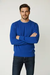 Buzo de cuello redondo en color azul vibrante, confeccionado en tejido de punto fino con puños y ruedo acanalados.