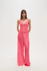 Pantalon de tiro bajo con diseño de aberturas laterales pronunciadas, unidas por argollas metálicas. Presenta un estampado animal print tipo cebra en tonos fucsia y rosado, con corte amplio y fluido.