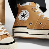 Zapatillas Converse Chuck Taylor All Star Lift de caña alta color marrón, con cordones blancos y plataforma con rayas negras.