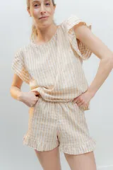 Pijama de algodón estampado Vichy, compuesto por una blusa de escote redondo y sin mangas con volados, y un short con elástico en la cintura y volados en el ruedo.