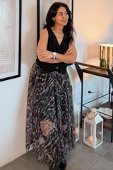 Falda larga de corte evasé con estampado animal print en tonos oscuros y grises, confeccionada en tejido translúcido.