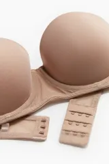 Soutien balconette acolchado de microfibra color beige, sin tirantes, con aros y copas formadas.