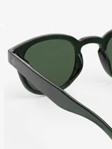 Lentes de sol de acetato color verde oscuro, con forma redonda y patillas flexibles.