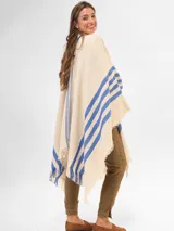 Poncho color crema con rayas horizontales azules y flecos en el ruedo.