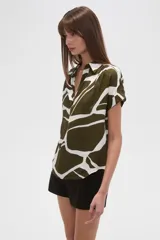 Blusa holgada de manga corta, con escote en V y estampado abstracto en tonos verde oliva y blanco.