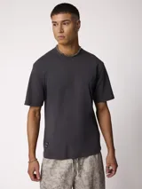 Remera básica gris oscuro con cuello redondo y mangas cortas, de corte relajado.