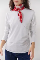 Remera blanca de manga larga con cuello redondo y costuras decorativas en contraste de color negro.