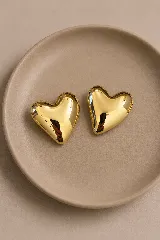 Aros con diseño de corazón inflado en acabado dorado brillante.
