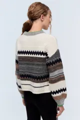 Sweater de lana merino color crudo con diseño geométrico, cuello redondo con detalle de color verde y lentejuelas delicadas.