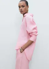Camisa rosa de lino, de corte oversize, manga larga con puños abotonados y cuello camisero.