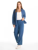 Cardigan abierto de denim, de corte holgado y recto, con solapas amplias, bolsillos frontales funcionales y hombros caídos.