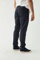 Pantalón chino de hombre color azul marino, confeccionado en gabardina. Presenta un calce regular, cierre con cremallera y botón, y bolsillos laterales y traseros.
