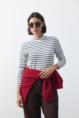 Polera de cuello alto con diseño de rayas horizontales en color azul marino sobre fondo blanco, confeccionada en tejido de punto con mangas largas.