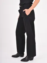 Pantalon de corte recto y tiro medio, confeccionado en tela de algodón color negro, con cierre frontal y bolsillos laterales.