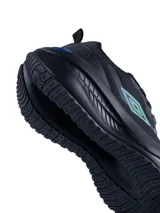 Championes deportivos Umbro modelo Fly, color negro con detalles en azul y verde neón en el logo lateral y la parte trasera. Presentan una suela robusta y diseño ergonómico.