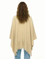 Ruana de tejido soft color negro, con cuello en V y un nudo o pasador frontal que ajusta la prenda. Los bordes tienen terminación desflecada.