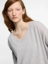 Sweater azul marino de tejido de punto con escote en V y detalles de hilo metálico brillante.