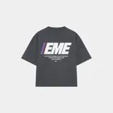 Remera oversized color gris oscuro, con estampado frontal y trasero del logo "EME" en blanco con detalles en azul y rojo, y texto adicional en blanco. Confeccionada en 100% algodón y con corte cropped.