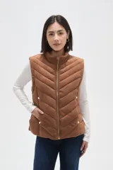 Chaleco acolchado color marrón con diseño capitoneado en forma de espiga, cierre frontal completo y botones decorativos dorados en los laterales.