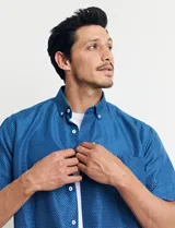 Camisa azul con estampado de lunares blancos, de manga corta y corte clásico.