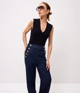 Pantalón wide leg de jean azul oscuro, de talle alto con calce amplio y detalles de botones dorados en el lateral frontal.