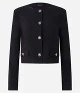 Saco corto de crepé en color negro, con cuello redondo, cierre frontal de botones metálicos y bolsillos con solapa en el frente. Presenta mangas largas y un diseño estructurado.